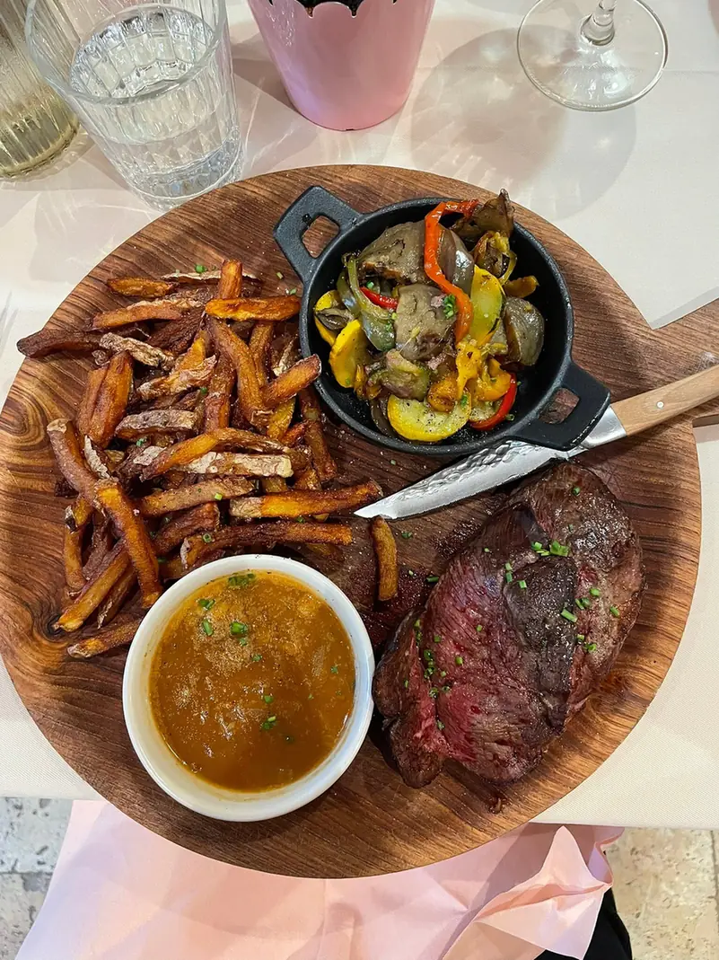 Viande grillée, frites de patate douce et légumes en cocotte, sur planche
