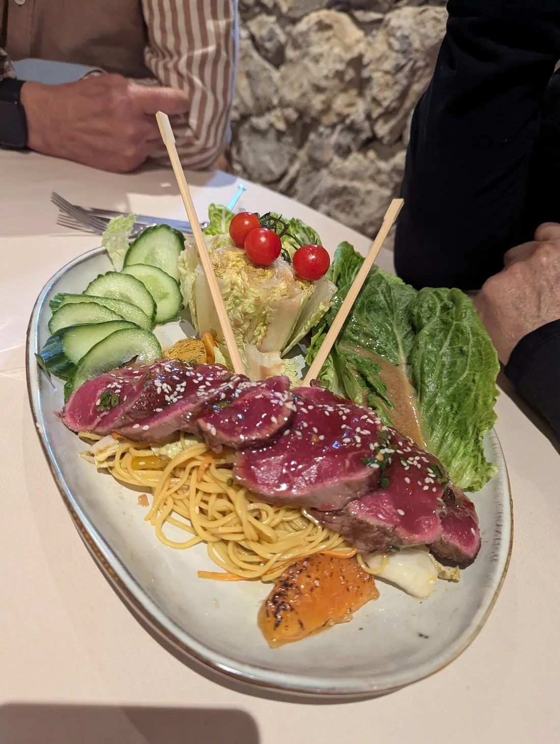 Tranches de viande saisie au sésame, nouilles et crudités
